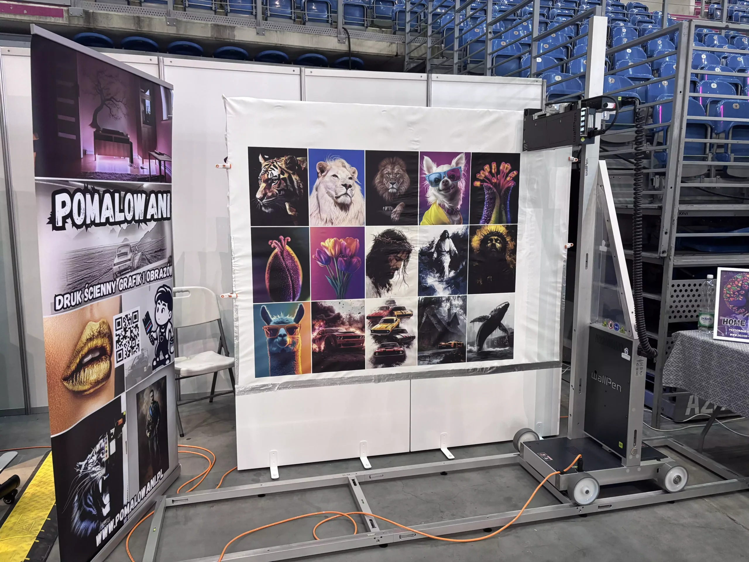 Pokaz druku ściennego i na materiałach w Tauron Arenie – pionowa drukarka UV Pomalowani.pl prezentująca galerię kolorowych grafik z motywami zwierząt i aut
