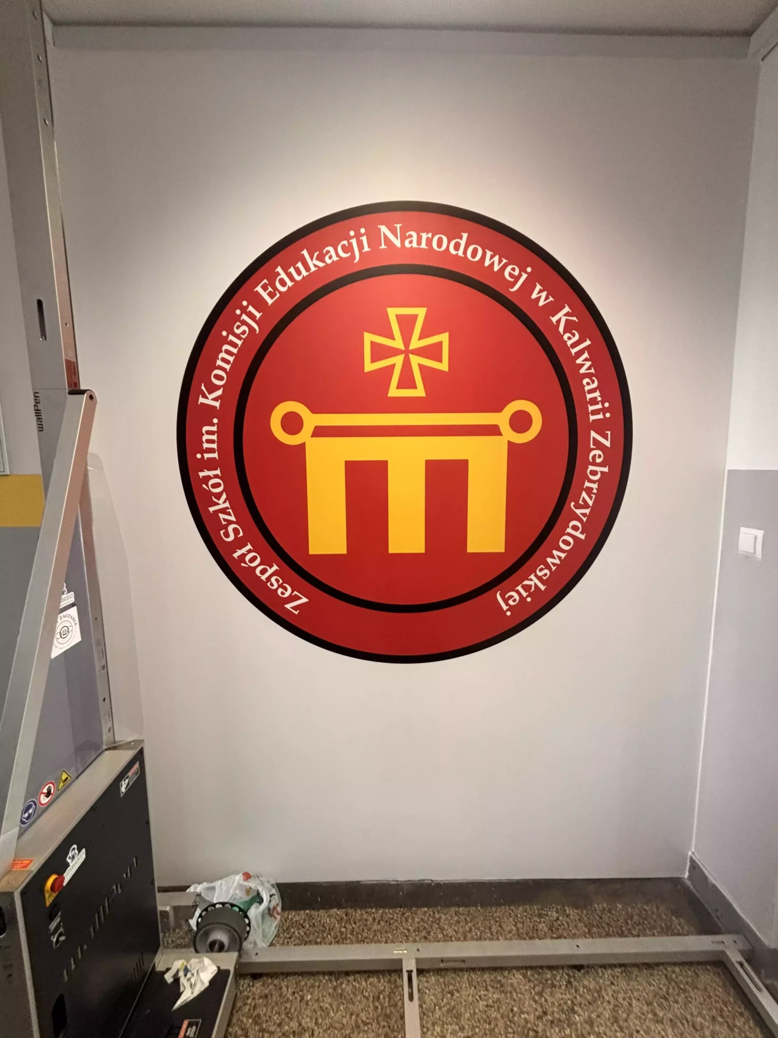 wydrukowane na ścianie logo w Zespole Szkół imienia Komisji Edukacji Narodowej w Kalwarii Zebrzydowskiej