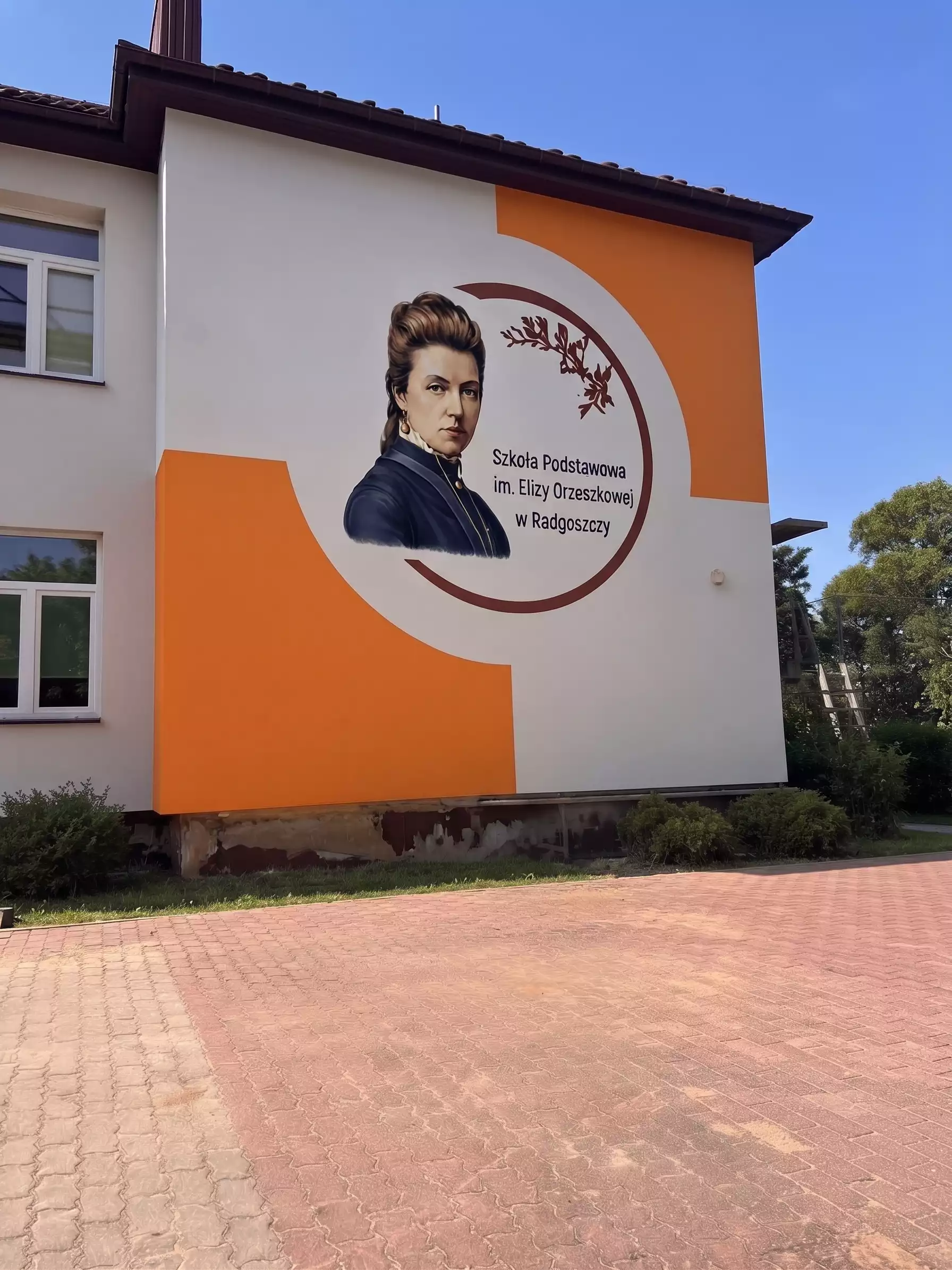 Mural Elizy Orzeszkowej na ścianie elewacyjnej Szkoły Podstawowej w Radgoszczy wykonany nowoczesną technologią druku ściennego